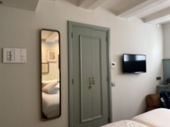 mirror and door to bathroom inside hotel room at the times hotel amsterdam