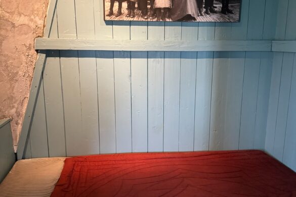 simple bedroom with bed inside historic Kinderdijk windmill living quarters