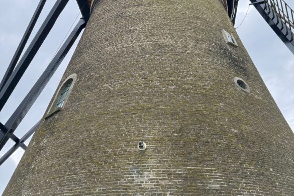 historic Kinderdijk windmill tower viewed from below under cloudy sky in the Netherlands