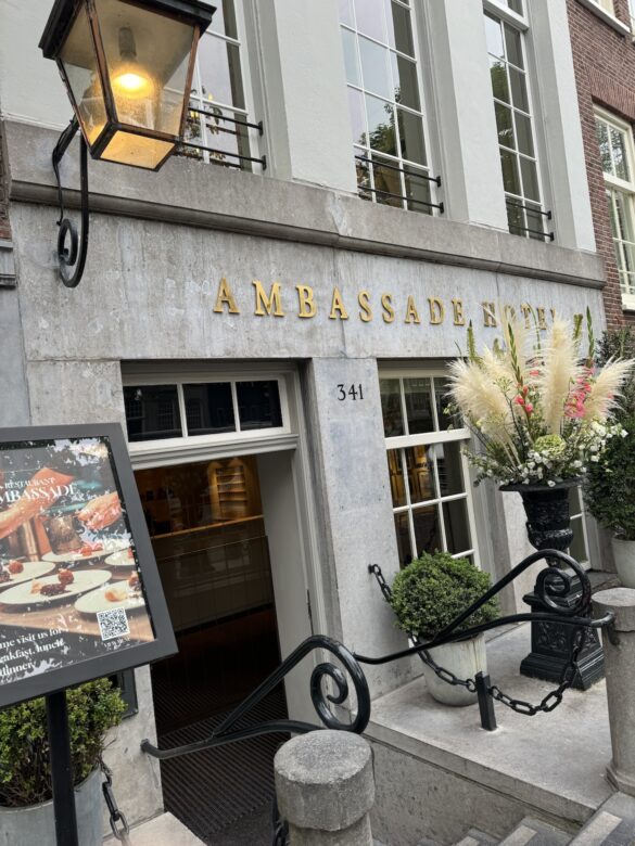 Entrance of the Ambassade Hotel in Amsterdam with lantern and floral urn