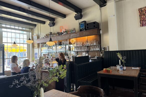 interior of Café de Prins in Amsterdam with bar, tables, and natural light from windows