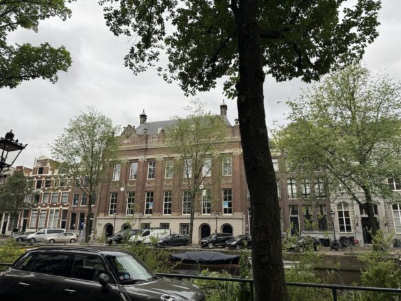 Historic canal houses and trees along a canal street in Amsterdam