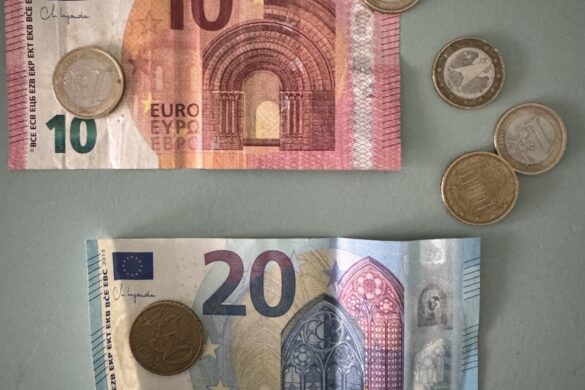 Close view of ten and twenty euro banknotes with assorted euro coins