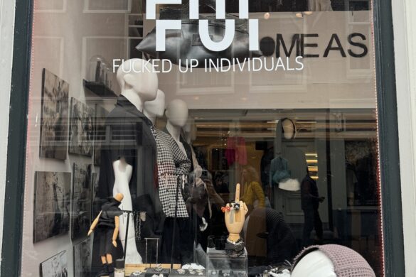 Amsterdam storefront window with provocative fashion branding and mannequins