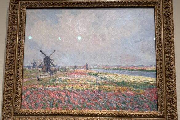 Claude Monet painting of Dutch tulip fields near The Hague with windmills beneath a luminous sky, photographed at the Van Gogh Museum in Amsterdam