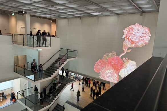 Visitors in the Van Gogh Museum beside large projected floral details from Van Gogh paintings
