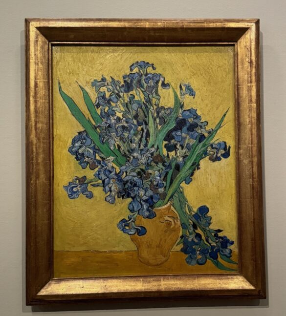 Vincent van Gogh painting Irises in a yellow vase against a golden background at the Van Gogh Museum