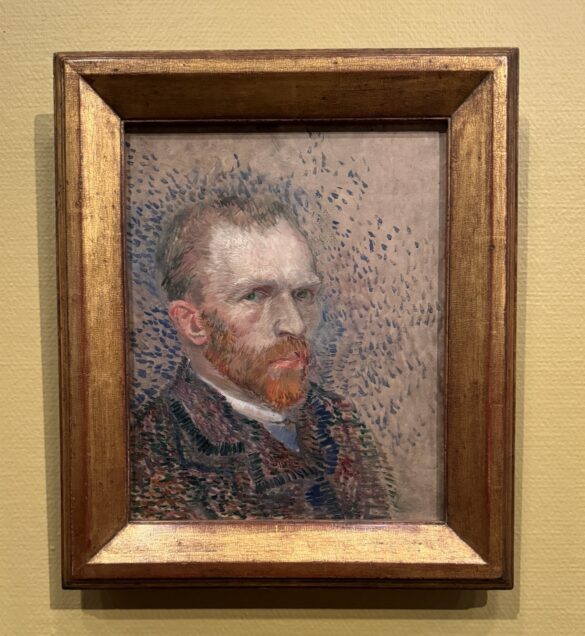 Vincent van Gogh self-portrait in gilded frame with blue stippled background and red beard at the Van Gogh Museum