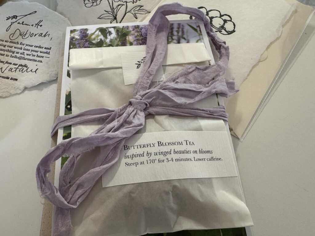 Farmette Package Unwrapped Opened Farmette package with silk ribbon, handmade paper, and stationery items.