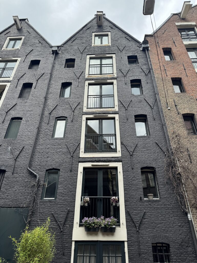 Looking Up at an Amsterdam Canal House Looking up at a narrow historic canal house in Amsterdam