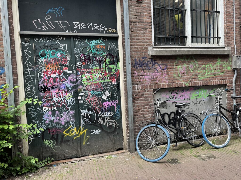 Street Art and Bicycle in Amsterdam Graffiti-covered doorway with a bicycle parked beside it in Amsterdam