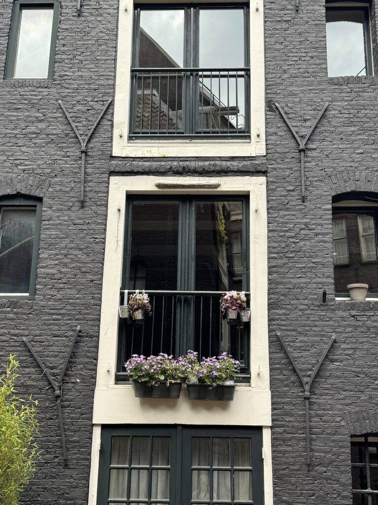 Flower boxes on the windows of a historic Amsterdam canal house