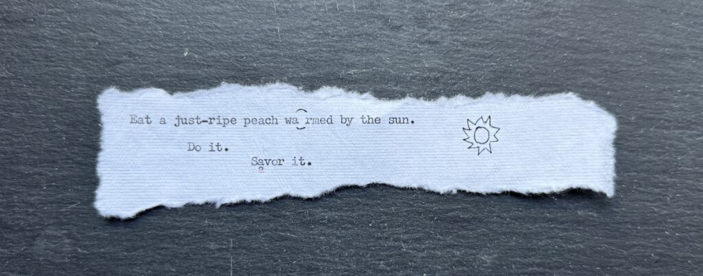 Torn typewritten note reading “Eat a just-ripe peach warmed by the sun” with a hand-drawn sun